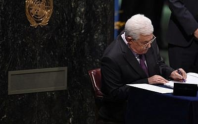 Palestinian Authority President Mahmud Abbas signs papers at the high level signature ceremony for the Paris Agreement at  the United Nations General Assembly Hall on April 22, 2016 . (AFP PHOTO/TIMOTHY A. CLARY)