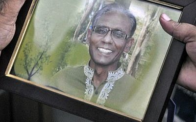 A man holds a portrait of Bangladeshi professor Rezaul Karim Siddique, who was hacked to death by unidentified attackers, in Rajshahi on April 23, 2016. 
(Md. Abdullah Iqbal/AFP)