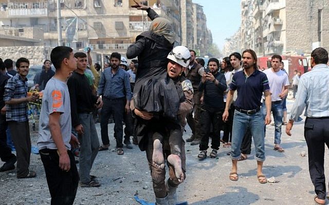 A Syrian civil defense volunteer evacuates a woman following a reported airstrike on April 23, 2016 in the rebel-held neighborhood of Tareeq al-Bab in the northern city of Aleppo. (Ameer Alhalbi/AFP) A Syrian civil defense volunteer evacuates a woman following a reported airstrike on April 23, 2016 in the rebel-held neighborhood of Tareeq al-Bab in the northern city of Aleppo. (Ameer Alhalbi/AFP)