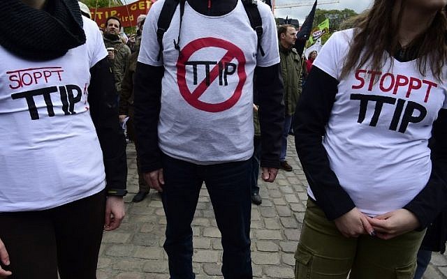 Opponents of a proposed transatlantic trade deal (TTIP) wear T-shirts reading 'Stop TTIP' during a prostest rally on the eve of US President's vist to Hannover on April 23, 2016. (AFP PHOTO / John MACDOUGALL)