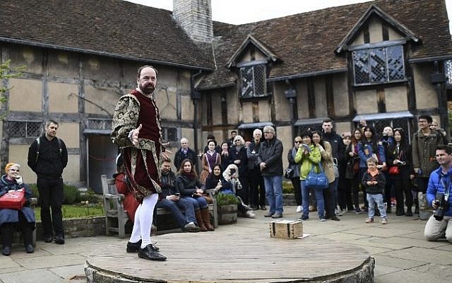 People watch the performance of excerts of a Shakespeare play in the grounds of the birthplace of William Shakespeare during events marking 400 years since the bard's death in Stratford-upon-Avon in central England on April 23, 2016. AFP / LEON NEAL)