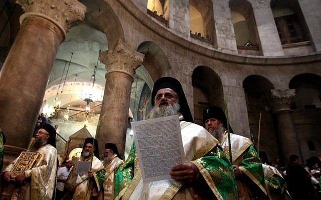 Greek Orthodox priests hold palm branches as they circle the aedicule during the Palm Sunday Easter procession at the Church of the Holy Sepulchre in Jerusalem's Old City on April 24, 2016 (AFP/Gali Tibbon) Greek Orthodox priests hold palm branches as they circle the aedicule during the Palm Sunday Easter procession at the Church of the Holy Sepulchre in Jerusalem's Old City on April 24, 2016 (AFP/Gali Tibbon)