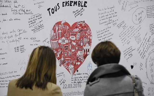 People read messages on a commemorative wall at the Maelbeek - Maalbeek metro station on its re-opening day on April 25, 2016 in Brussels, after being closed since the 22 March attacks in the Belgian capital. (AFP PHOTO / JOHN THYS)