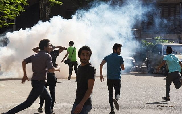 Egyptian protesters run for cover from tear gas fired by riot police during a Cairo demonstration against the handing over of two Red Sea islands to Saudi Arabia, April 25, 2016. (AFP Photo/Mohamed el-Shahed) Egyptian protesters run for cover from tear gas fired by riot police during a Cairo demonstration against the handing over of two Red Sea islands to Saudi Arabia, April 25, 2016. (AFP Photo/Mohamed el-Shahed)
