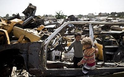 Palestinian children play in abandoned vehicles in an impoverished area in the southern Gaza Strip city of Khan Younis, on April 26, 2016. (AFP/Mahmud Hams)
