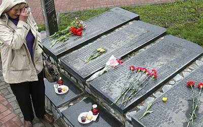 A woman cries at the Chernobyl victims' memorial in the Ukrainian capital of Kiev on April 26, 2016. (AFP PHOTO / Anatolii Stepanov)