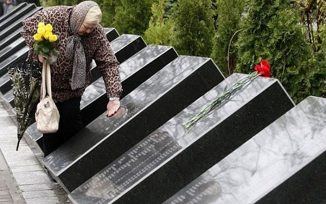 A woman mourns at the Chernobyl victims' memorial in the Ukrainian capital of Kiev on April 26, 2016. (AFP PHOTO / Anatolii Stepanov)