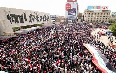 Iraqi supporters of the Sadrist movement hold national flags and shout slogans during a demonstration to press for reforms on April 26, 2016, at Baghdad's Tahrir Square. (AFP PHOTO / HAIDAR MOHAMMED ALI)