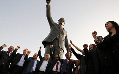 Palestinian and South African officials pose in front of a giant statue of Nelson Mandela during its inauguration ceremony in the West Bank city of Ramallah on April 26, 2016. (AFP PHOTO / ABBAS MOMANI)