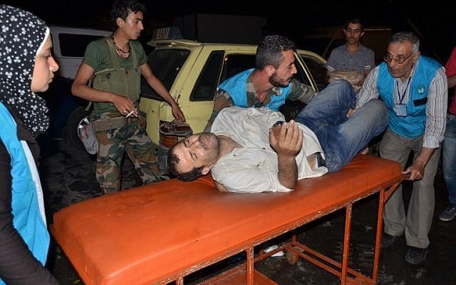 Syrian civil defense members carry a wounded man on a stretcher into a hospital in the government-controlled side of the northern city of Aleppo following clashes on April 27, 2016. (AFP/George Ourfalian)