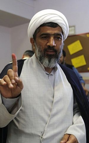 An Iranian cleric displays his ink-stained finger after casting his ballot for the second round of parliamentary elections at a polling station in the town of Robat Karim, some 40 kms southwest of the capital Tehran, on April 29, 2016. (AFP PHOTO/ATTA KENARE)