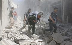 Syrians evacuate an injured man amid the rubble of destroyed buildings following a reported airstrike on the rebel-held neighborhood of Al-Qatarji, in the northern Syrian city of Aleppo, on April 29, 2016. (AFP/Ameer Alhabi)