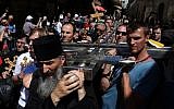 Serbian Orthodox Christian pilgrims carry a large metal cross from Serbia along the Via Dolorosa (Way of Suffering), during the Good Friday procession in Jerusalem's Old City on April 29, 2016. (Gali Tibbon/AFP)