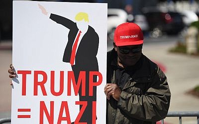 A protester holds up a sign during a protest outside the Hyatt Regency Hotel where republican presidential candidate Donald Trump was speaking in Burlingame, California on April 29, 2016.  
Hundreds of protesters jostled with police in riot gear outside a California hotel where Republican presidential frontrunner Donald Trump was to give a speech, forcing the candidate to duck into a back entrance. (AFP PHOTO / Josh Edelson)