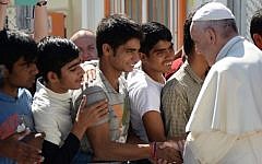 Pope Francis greets migrants and refugees at the Moria refugee camp on April 16, 2016 near the port of Mytilene, on the Greek island of Lesbos. (AFP PHOTO POOL/FILIPPO MONTEFORTE)