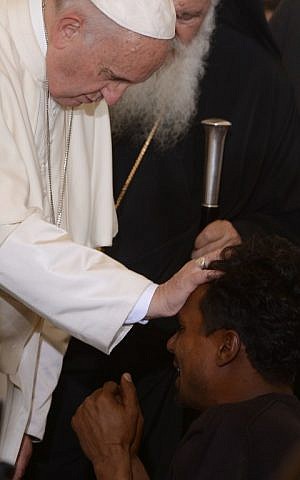 Pope Francis blesses a man kneeling in front of him as he greets migrants and refugees at the Moria refugee camp on April 16, 2016 near the port of Mytilene, on the Greek island of Lesbos. (AFP PHOTO/POOL/FILIPPO MONTEFORTE) Pope Francis blesses a man kneeling in front of him as he greets migrants and refugees at the Moria refugee camp on April 16, 2016 near the port of Mytilene, on the Greek island of Lesbos. (AFP PHOTO/POOL/FILIPPO MONTEFORTE)