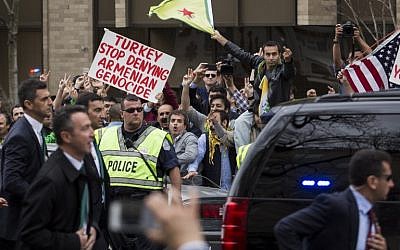 Protestors rallying against Turkish President Recep Tayyip Erdogan gesture toward his motorcade as it exits outside of the Brookings Institution, March 31, 2016 in Washington, DC. (Drew Angerer/Getty Images/AFP)