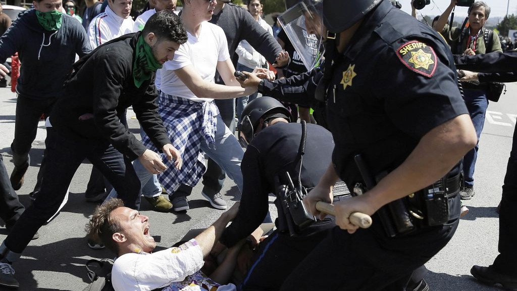 Police officers take a man into custody who was protesting Republican presidential candidate Donald Trump outside of the Hyatt Regency hotel during the California Republican Party 2016 Convention in Burlingame, Calif., Friday, April 29, 2016. (AP Photo/Eric Risberg) Police officers take a man into custody who was protesting Republican presidential candidate Donald Trump outside of the Hyatt Regency hotel during the California Republican Party 2016 Convention in Burlingame, Calif., Friday, April 29, 2016. (AP Photo/Eric Risberg)