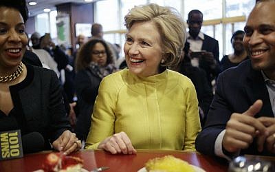 Democratic presidential candidate Hillary Clinton, center, talks with Rep. Hakeem Jeffries, D-New York, right, and Council Member Laurie Cumbo as she sits at the counter of Junior's restaurant in the Brooklyn borough of New York, Saturday, April 9, 2016. (AP Photo/Seth Wenig)