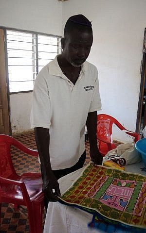 Ben Baigoo, a tailor and farmer, makes challah covers that the community sells to raise funds to build the synagogue and guest house. (Melanie Lidman/Times of Israel)