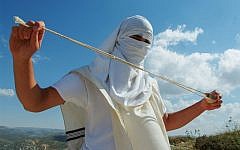 Illustrative photo of a masked Jewish settler holding a slingshot as he stands near the West Bank Jewish settlement of Mitzpeh Yitzhar, on May 19, 2013. (Mendy Hechtman/Flash90)