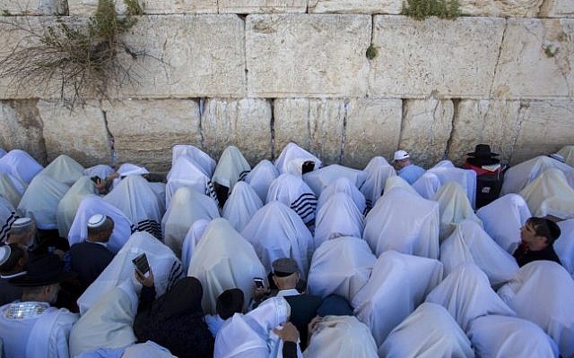 Jewish worshippers cover themselves with prayer shawls as they pray in front of the Western Wall, in Jerusalem's Old City, during the Jewish holiday of Passover on April 6, 2015. (Yonatan Sindel/Flash90)
