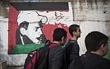 Kids seen walking home after school past a graffiti painting of Muhammed Abu Khdeir, the Palestinian child killed by Jewish extremists, with the Palestinian flag, on a central street in the Northern Arab-Israel. (Hadas Parush/Flash90)