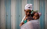 A member of theJewish Ethiopian community carries her baby on her back before attending the Passover prayer service, in the synagogue in Gondar, Ethiopia. April 22, 2016. (Miriam Alster/FLASH90)