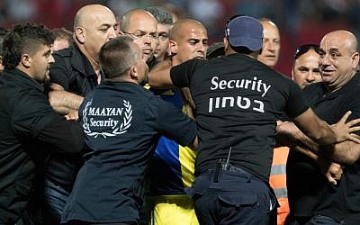 Bnei Sakhnin F.C. players and Maccabi Tel Aviv players pushing each other at the end of a game at the Doha Stadium in Sakhnin, April 25, 2016. (Roy Alima/Flash90)