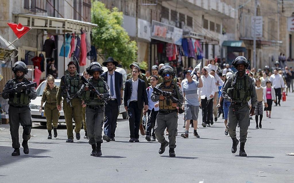 Israeli security forces guard Orthodox Jews visiting the divided West Bank city of Hebron for Passover, on April 26, 2016. (Photo by Wisam Hashlamoun/Flash90)