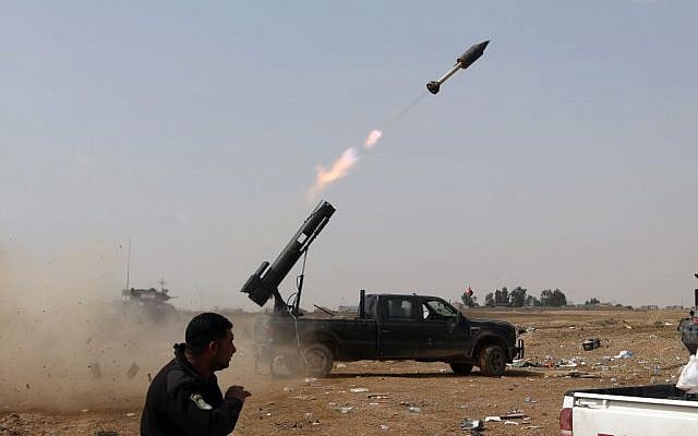 In this March 30, 2015, file photo, Iraqi security forces launch a rocket against Islamic State extremist positions during clashes in Tikrit, 130 kilometers (80 miles) north of Baghdad, Iraq. (AP/Khalid Mohammed)