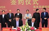(Foreground L to R) Asaf Gendler, CEO of Israeli start-up Bidflyer, signs a partnership agreement with Kevin Yu, COO of Hainan Eco-Tech Group (Courtesy)
