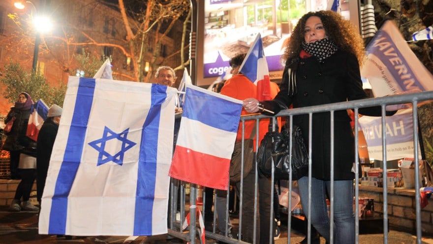French Jews waving Israeli and French flags outside the Hyper Cacher a year after four Jewish shoppers were killed in a terror attack on the Paris kosher market, January 9, 2016. (Serge Attal/Flash90) French Jews waving Israeli and French flags outside the Hyper Cacher a year after four Jewish shoppers were killed in a terror attack on the Paris kosher market, January 9, 2016. (Serge Attal/Flash90)