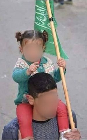 In an undated photo, the man named by Hamas as the person responsible for the April 18 bus bombing in Jerusalem holds a Hamas flag and carries an infant during a rally. He died of wounds sustained in the terror attack on April 20, 2016. (Courtesy)