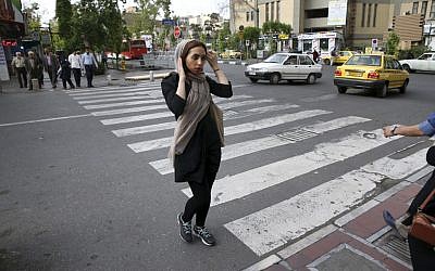 An Iranian woman adjusts her headscarf, while crossing a street in downtown Tehran, Iran, April 26, 2016. (AP Photo/Vahid Salemi)
