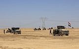 Iraq's elite counter terrorism forces advance through soft desert terrain outside the western Islamic State held town of Hit, 85 miles (140 kilometers) west of Baghdad, Iraq, Sunday, April 3, 2016. (AP/Khalid Mohammed)
