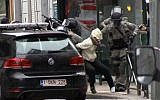 Screen capture from VTM shows Salah Abdeslam, center, as he is arrested by police and bundled into a police vehicle during a raid in the Molenbeek neighborhood of Brussels, Belgium, March 18, 2016. (VTM via AP)