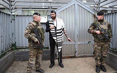 Illustrative: Soldiers guarding a staff member at a Chabad school in Paris, November 16, 2015. (Israel Bardugo/Courtesy of the International Fellowship of Christians and Jews/via JTA)