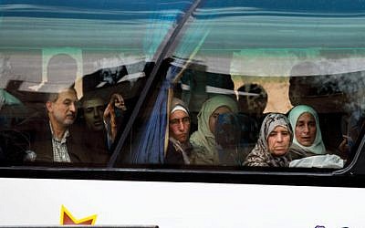 In this April 14, 2016 image, Syrians look through a window after they loaded their belongings onto a bus in the town of Palmyra in the central Homs province, Syria. (AP Photo/Hassan Ammar)