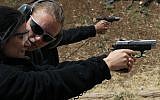 A woman fires a pistol at a shooting range in a settlement in Gush Etzion on May 02 2010 (Nati Shohat/Flash90)