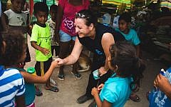 An IsraAID volunteer with Ecuadorean children in Canoa, Ecuador, on April 23 2016. (IsraAID)