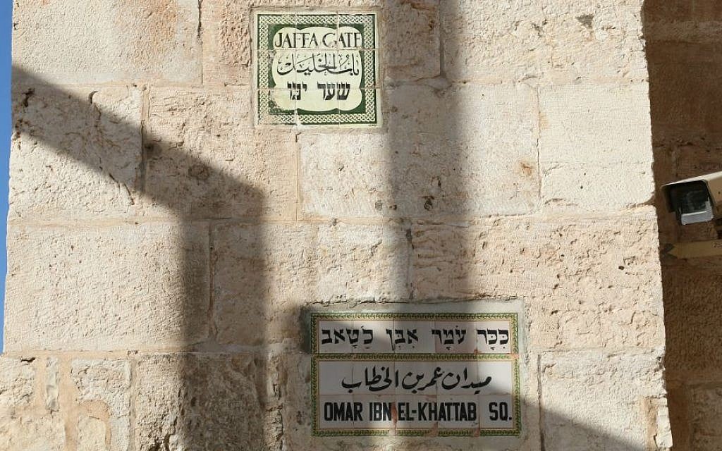 Signs and a security camera at the entrance to the city. (Shmuel Bar-Am)