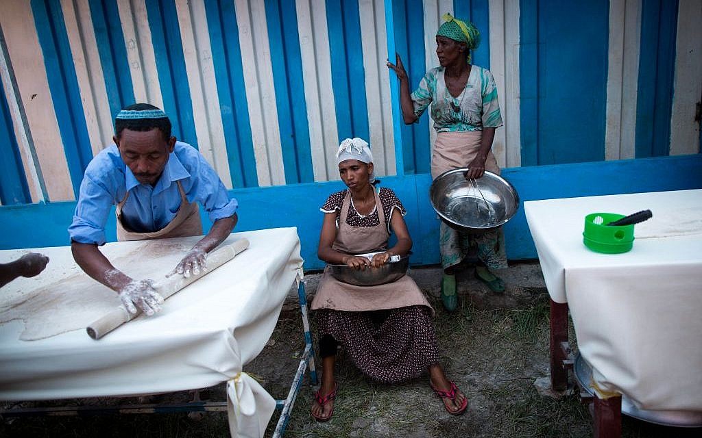 The men of Gondar's Jewish community mix the flour and water in eight minutes, before handing it off to the women who tend the fires.(Miriam Alster/Flash90)