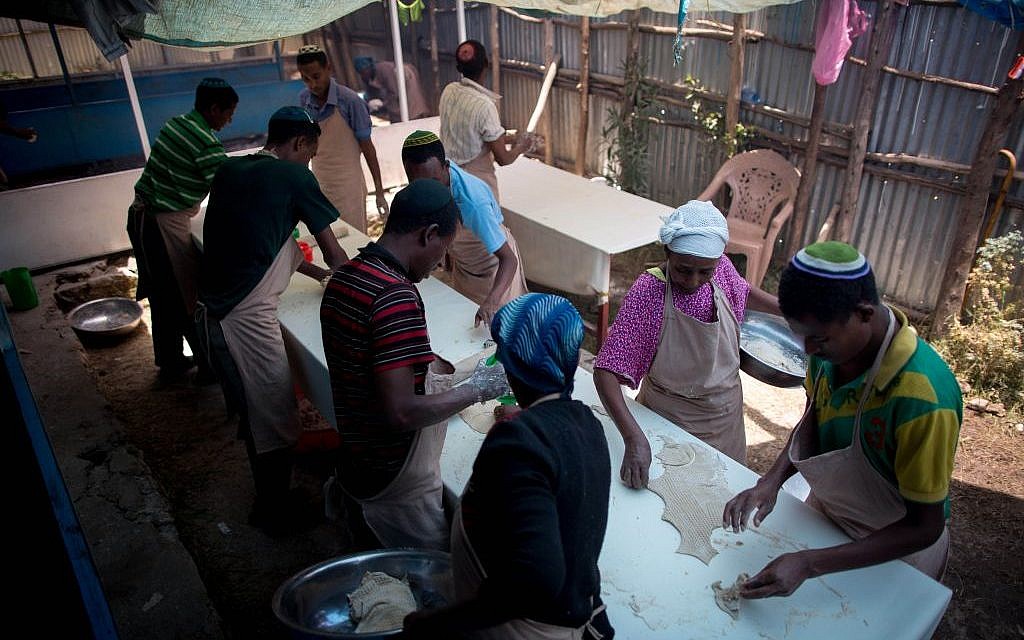The men of Gondar’s Jewish community use a large cookie cutter to cut the matzah into large circles on April 20, 2016. (Miriam Alster/Flash90)