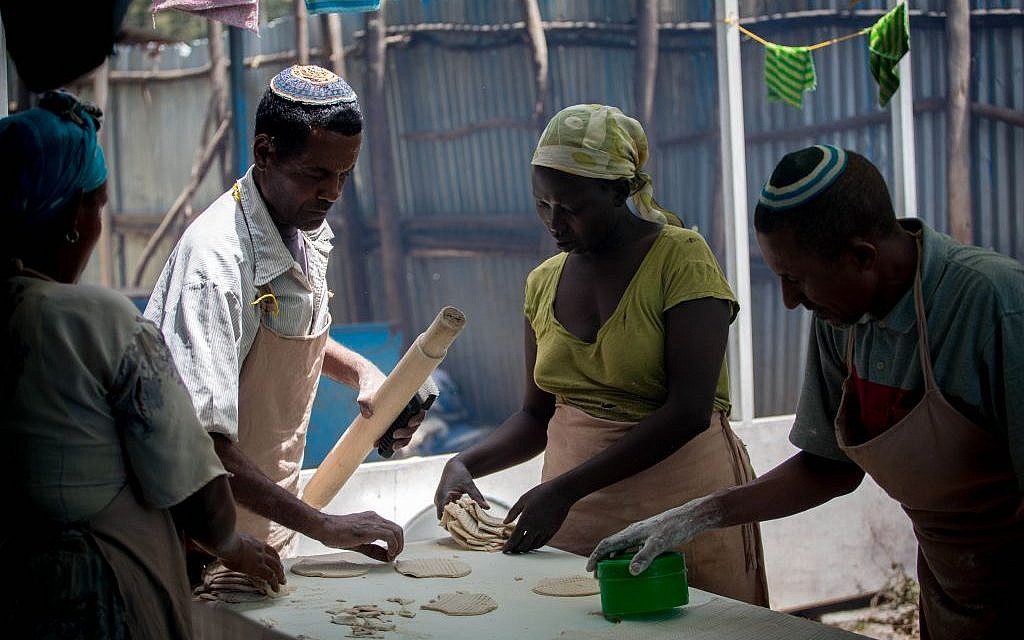 Illustrative: Members of the Gondar, Ethiopia, Jewish community prepare matzah before Passover on April 20, 2016. Women collect cut matzah dough to bring to the stove. (Miriam Alster/Flash90)