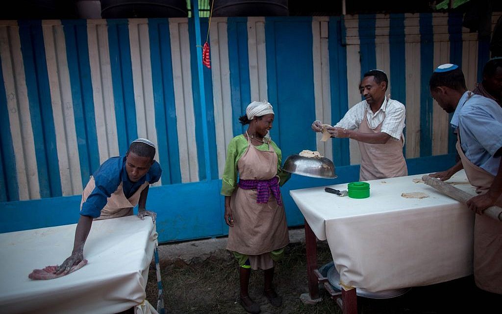 Members of Gondar's Jewish community prepare matzah before Passover on April 20, 2016. The matzah dough hand-off has to be done quickly and efficiently so that the matzah can be cooked in less than 18 minutes. (Miriam Alster/Flash90)