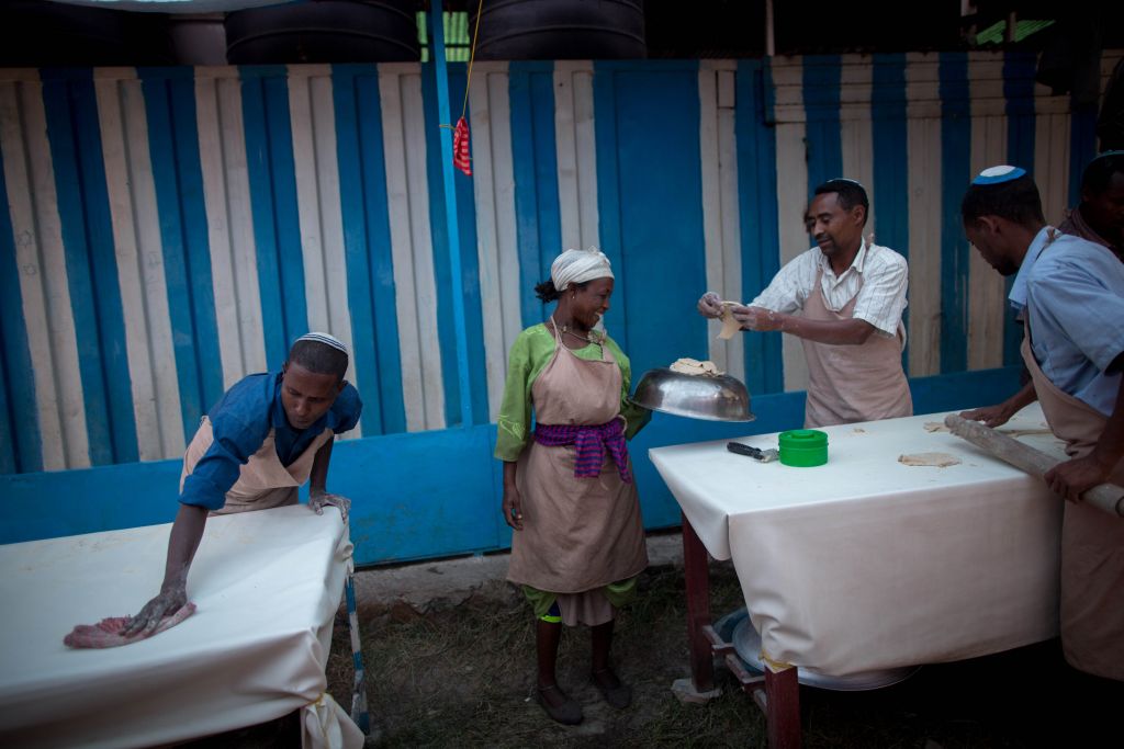 Members of Gondar's Jewish community prepare matzah before Passover on April 20, 2016. The matzah dough hand-off has to be done quickly and efficiently so that the matzah can be cooked in less than 18 minutes. (Miriam Alster/Flash90) Members of Gondar's Jewish community prepare matzah before Passover on April 20, 2016. The matzah dough hand-off has to be done quickly and efficiently so that the matzah can be cooked in less than 18 minutes. (Miriam Alster/Flash90)
