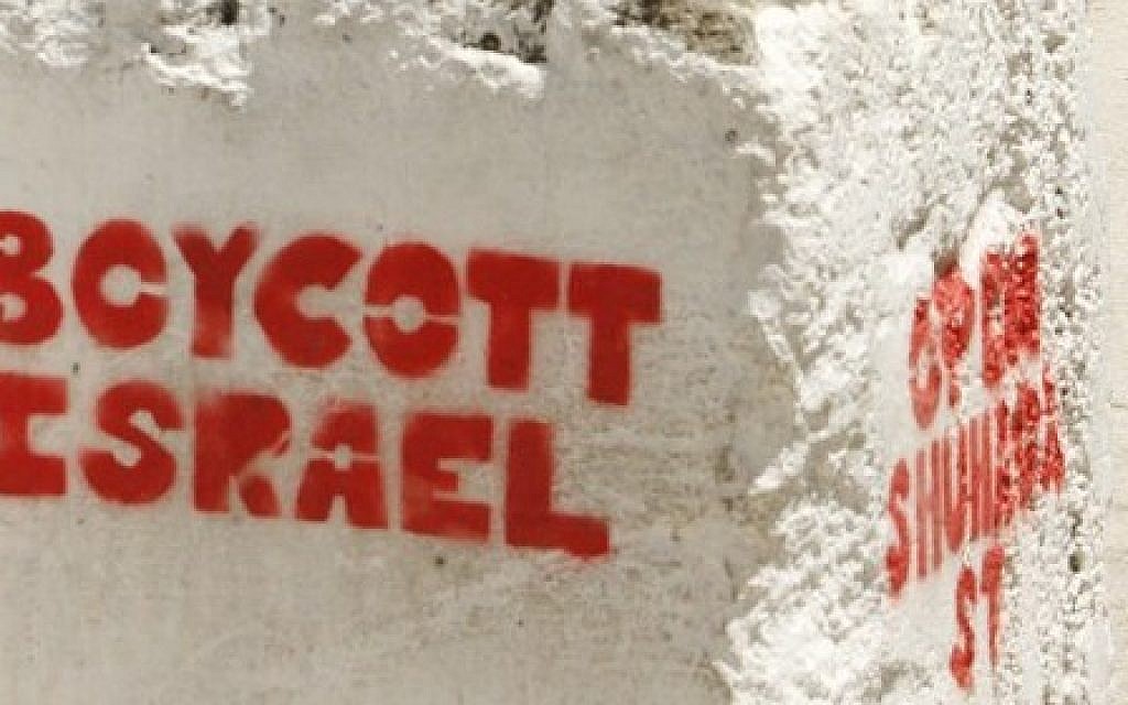 Graffiti sprayed on a roadblock in the West Bank city of Hebron reads 'Boycott Israel' (AFP Photo/Hazem Bader)