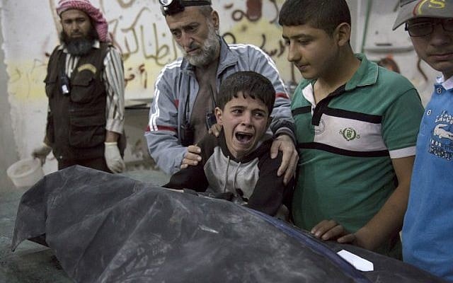 A Syrian boy is comforted as he cries next to the body of a relative who died in a reported airstrike on April 27, 2016 in the rebel-held neighborhood of al-Soukour in the northern city of Aleppo. (AFP PHOTO / KARAM AL-MASRI)
