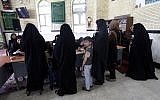 An Iranian young boy looks on as women arrive to cast their vote in the second round of parliamentary elections at a polling station in the town of Robat Karim, some 40 kms southwest of the capital Tehran, April 29, 2016. (AFP/ATTA KENARE)